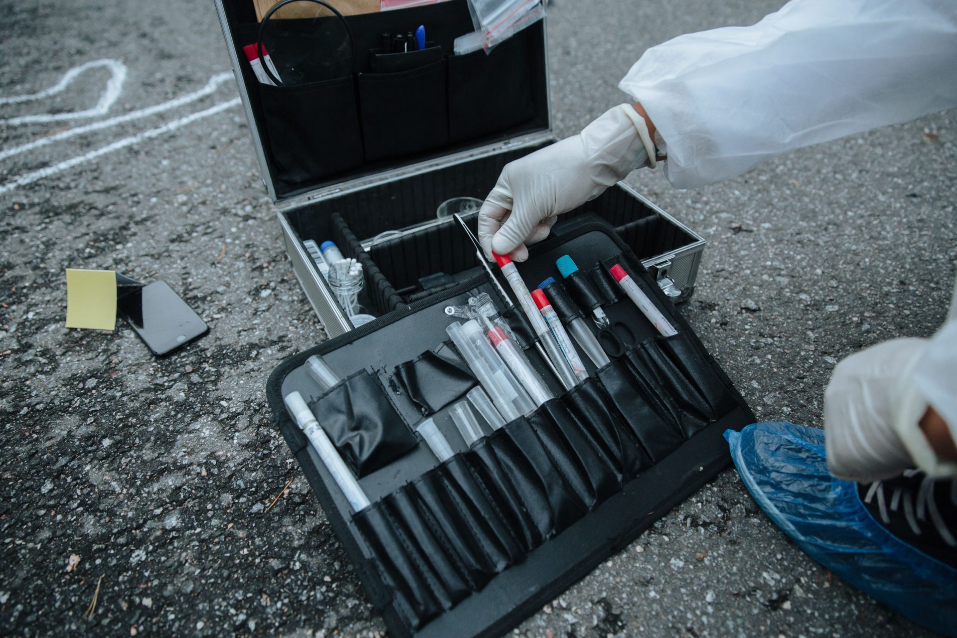 Nahaufnahme von Ermittlerwerkzeugen an einem Tatort, die Präzision und Detailreichtum verdeutlicht.